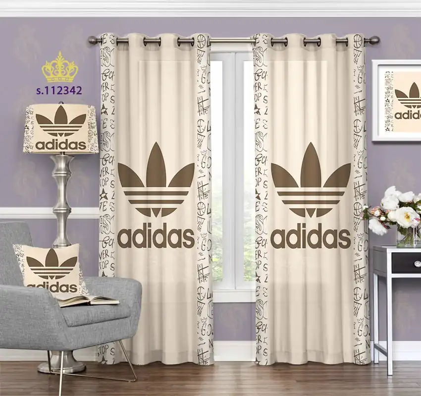 پرده کرم رنگ با طرح لوگوی بزرگ adidas و نوشته‌های پراکنده در حاشیه‌ها