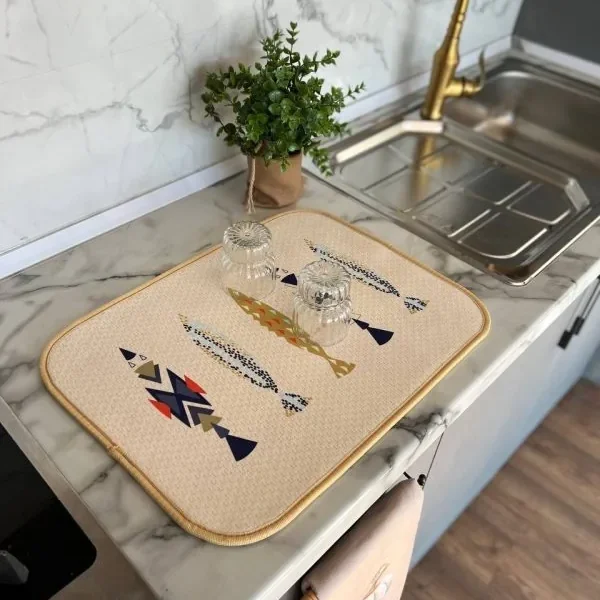 نم‌گیر آشپزخانه طرح Fish Art با ماهی‌های هندسی رنگی روی صفحه کابینت مرمری کنار سینک