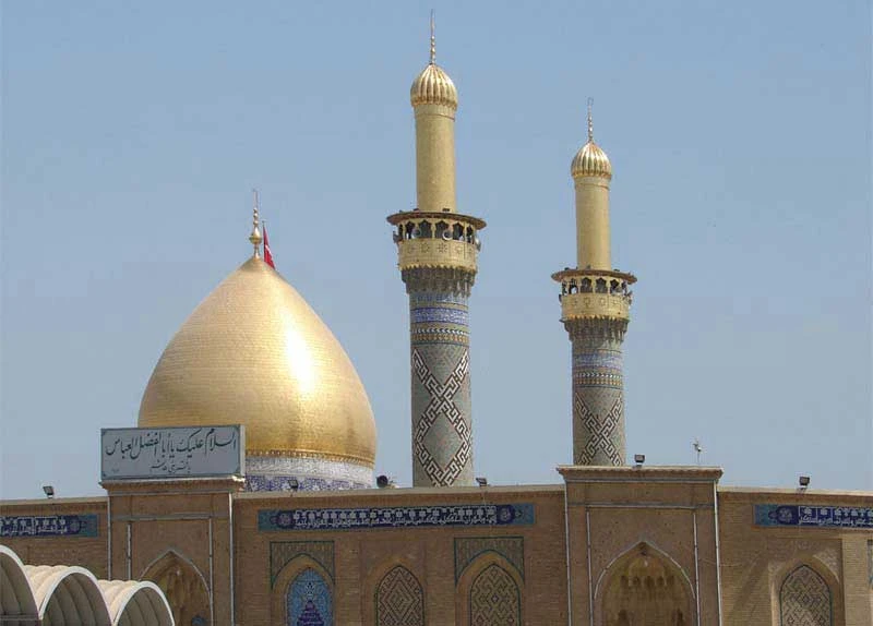 نمای گنبد و دو مناره طلایی حرم حضرت ابوالفضل در آسمان صاف